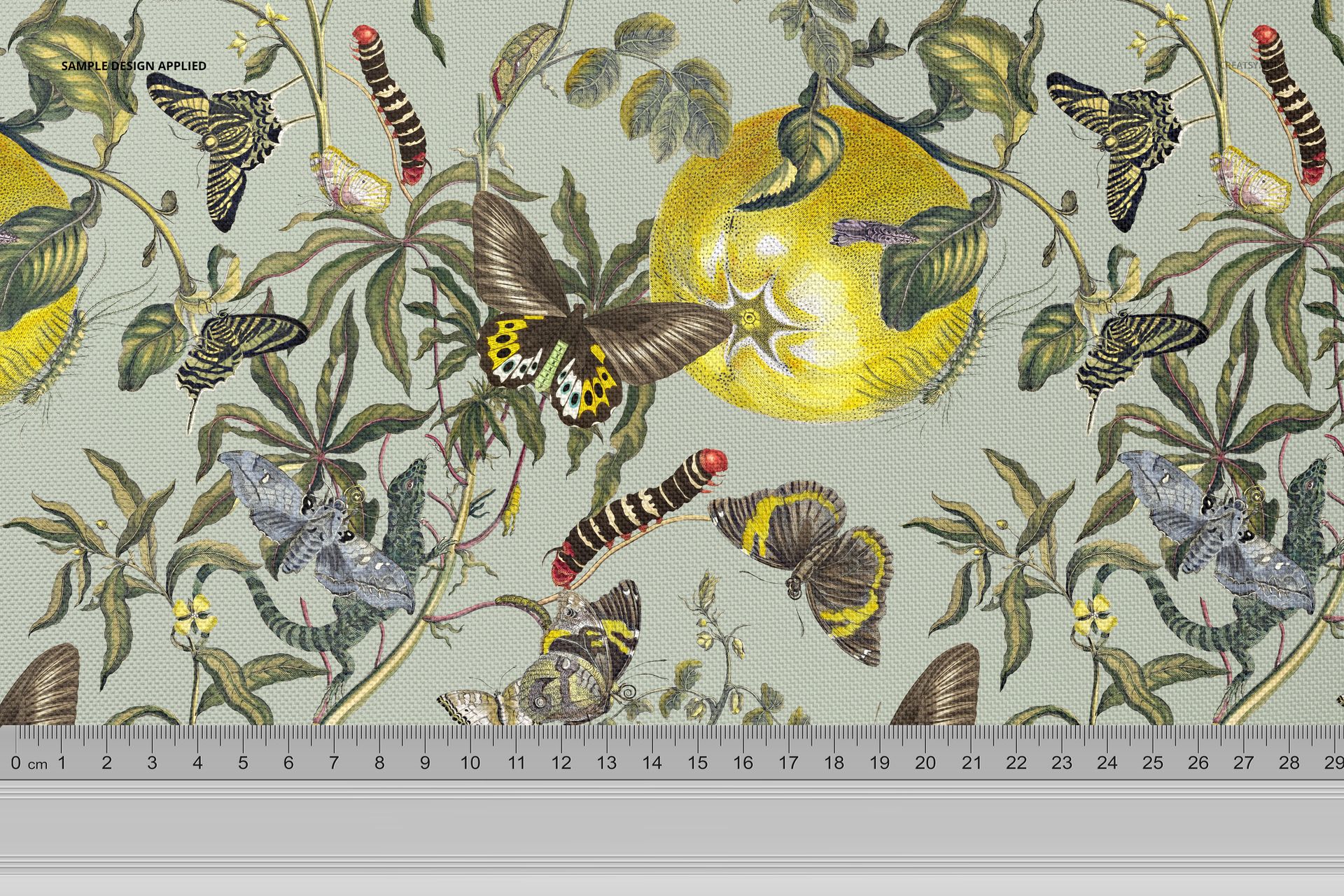 PSD mockup of fabric featuring a detailed nature-inspired design with butterflies, leaves, and a yellow fruit, ruler shown.