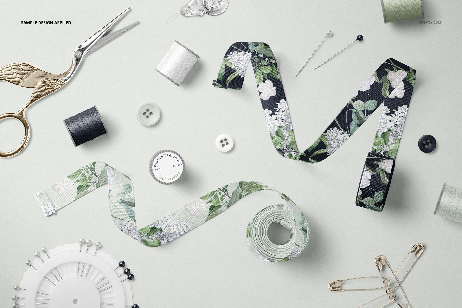 Grosgrain ribbon PSD mockup featuring two patterned ribbons among assorted sewing accessories on a light surface.