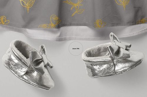 PSD mockup showing a gray baby dress with yellow floral accents and metallic silver baby shoes with decorative bows.