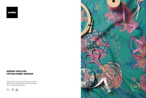 PSD mockup showing various sewing tools placed on colorful cotton fabric with botanical design, viewed from above.