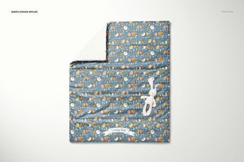 Top view of a baby quilt mockup featuring a colorful animal print and a white stuffed bunny placed on the quilt.