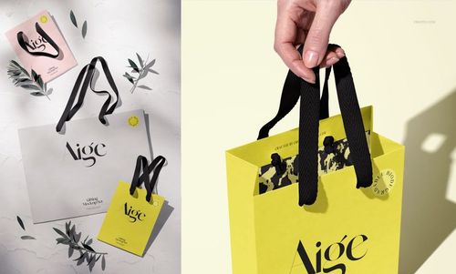 Mockup of paper gift bags featuring black cotton ribbon handles, minimalist background, and decorative olive leaves.