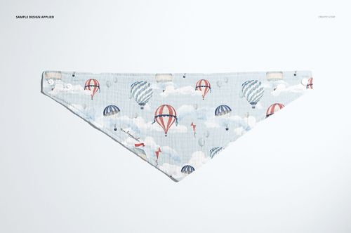 Triangular baby muslin bandana mockup featuring pastel hot air balloons and clouds, shown from above on a plain surface.
