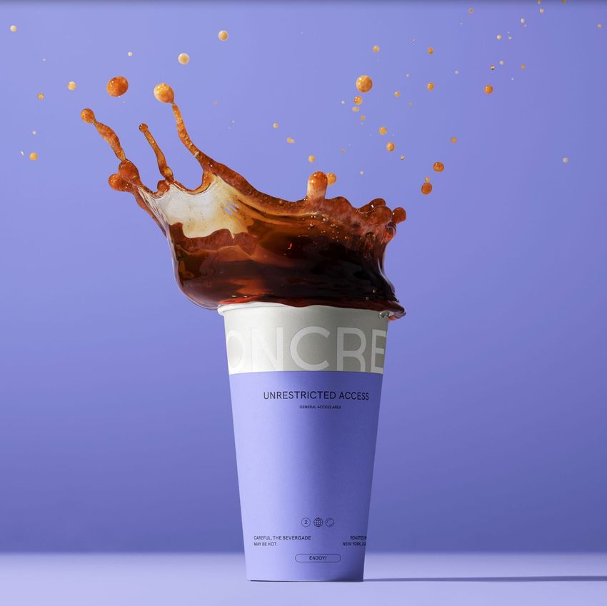 Paper cup mockup with a dynamic coffee splash erupting from the top, set against a solid lavender background.