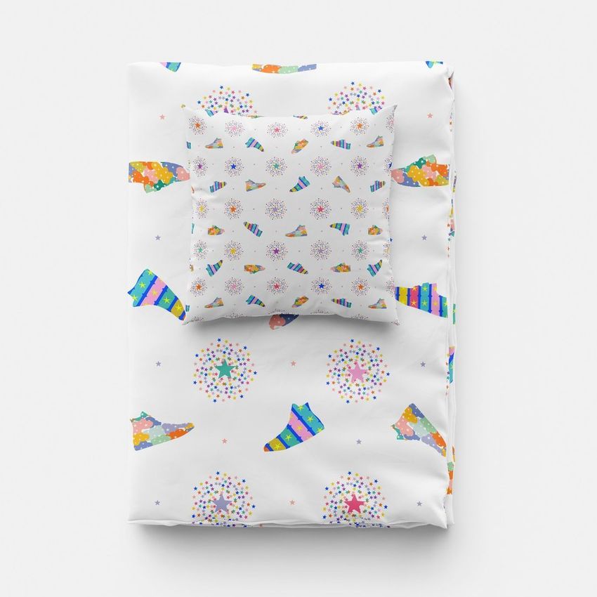 Folded duvet and pillow mockup featuring colorful sneaker and confetti patterns on a white background, viewed from above.