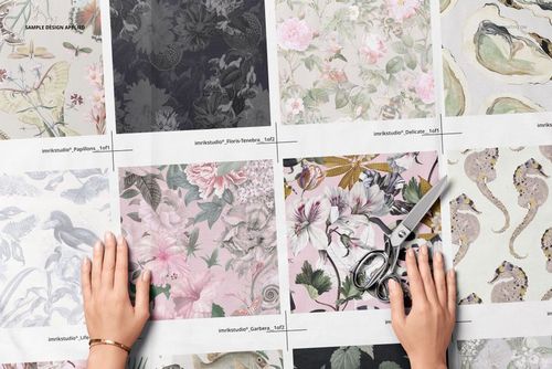 Top view of uncut cotton fabric samples mockup featuring various floral and animal patterns, hands and scissors visible.