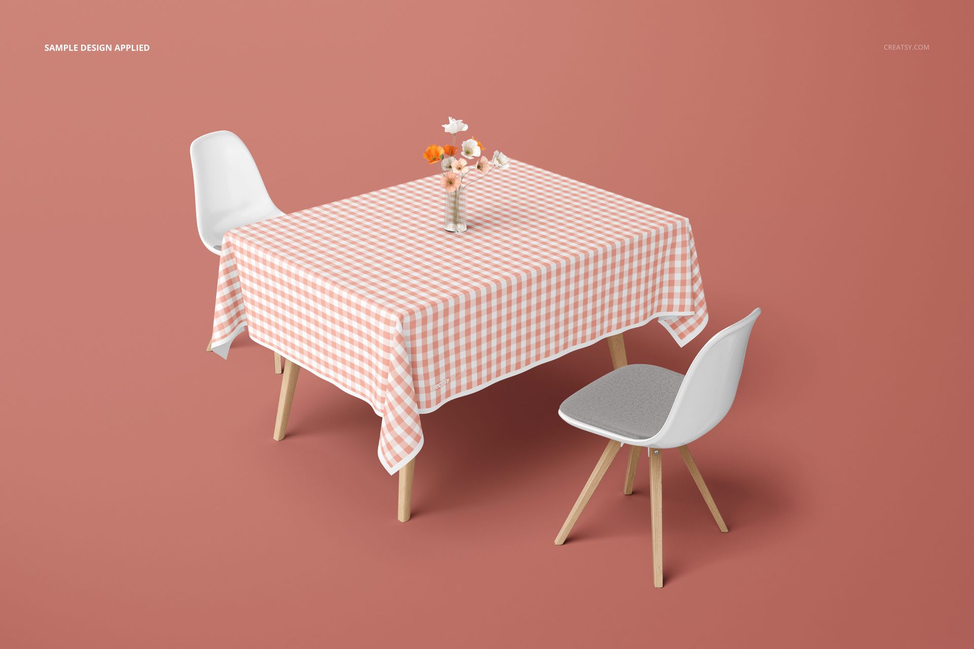 Tablecloth mockup on a dining table with a pink gingham pattern, surrounded by white chairs and a flower vase.