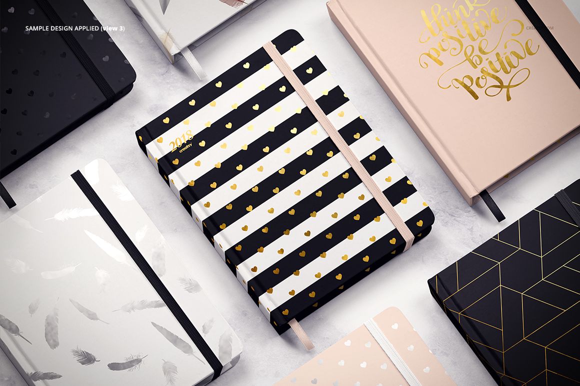 Stationery mockup set showing several closed planners with elastic bands, displaying diverse cover styles and colors.