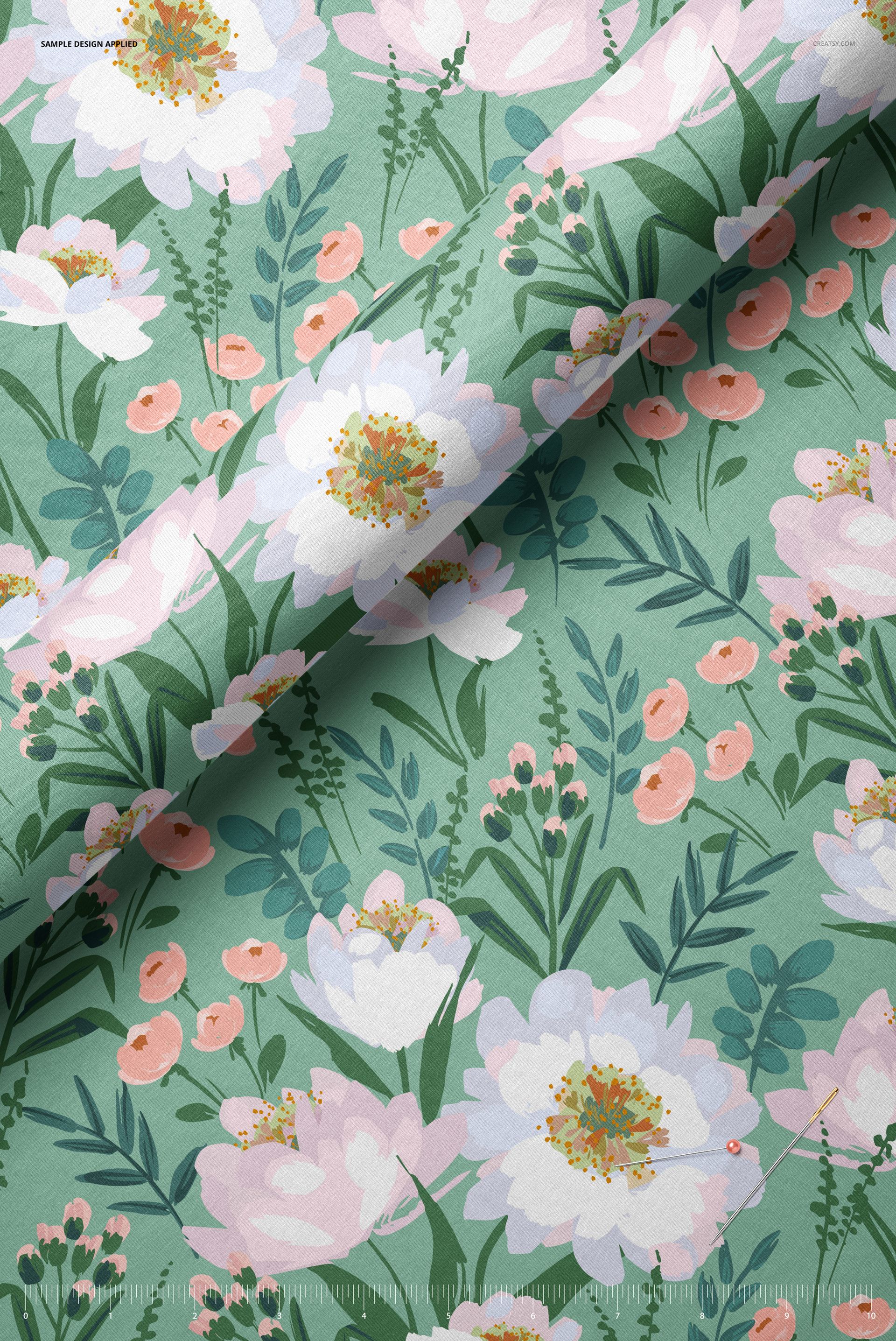 Close-up of jersey fabric mockup featuring a green background with white and pink floral pattern, viewed from above.