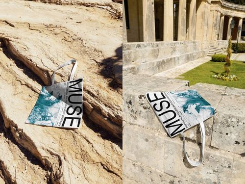 Outdoor PSD mockup showing a tote bag with artistic print and large lettering, placed on sunlit rocks and stone ruins.