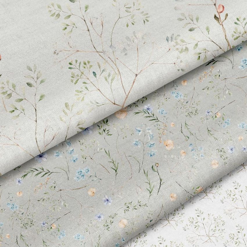 Cotton fabric mockup showing three folded fabric pieces with delicate botanical patterns in soft pastel colors on a light background.