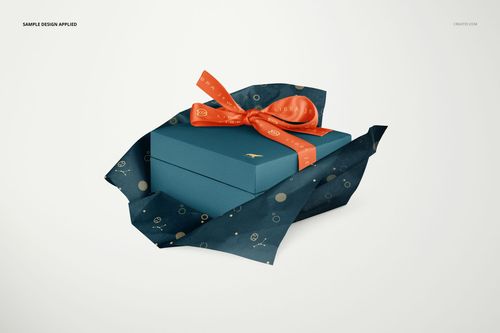 PSD mockup showing a jewelry box in blue, wrapped with dark tissue paper featuring gold dots and an orange bow.