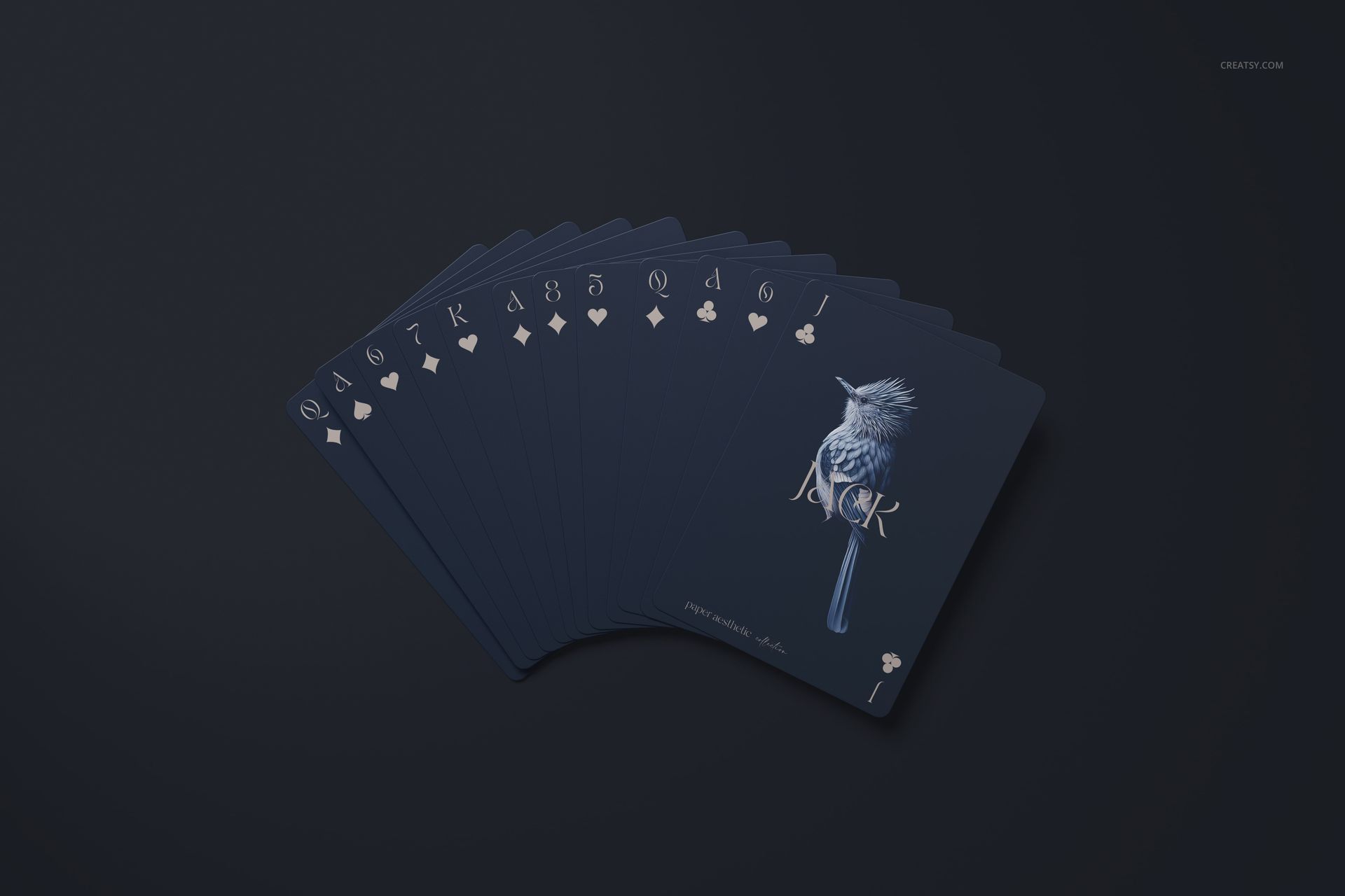 PSD mockup of playing cards spread out on a dark background, showing minimalist white designs and suits.