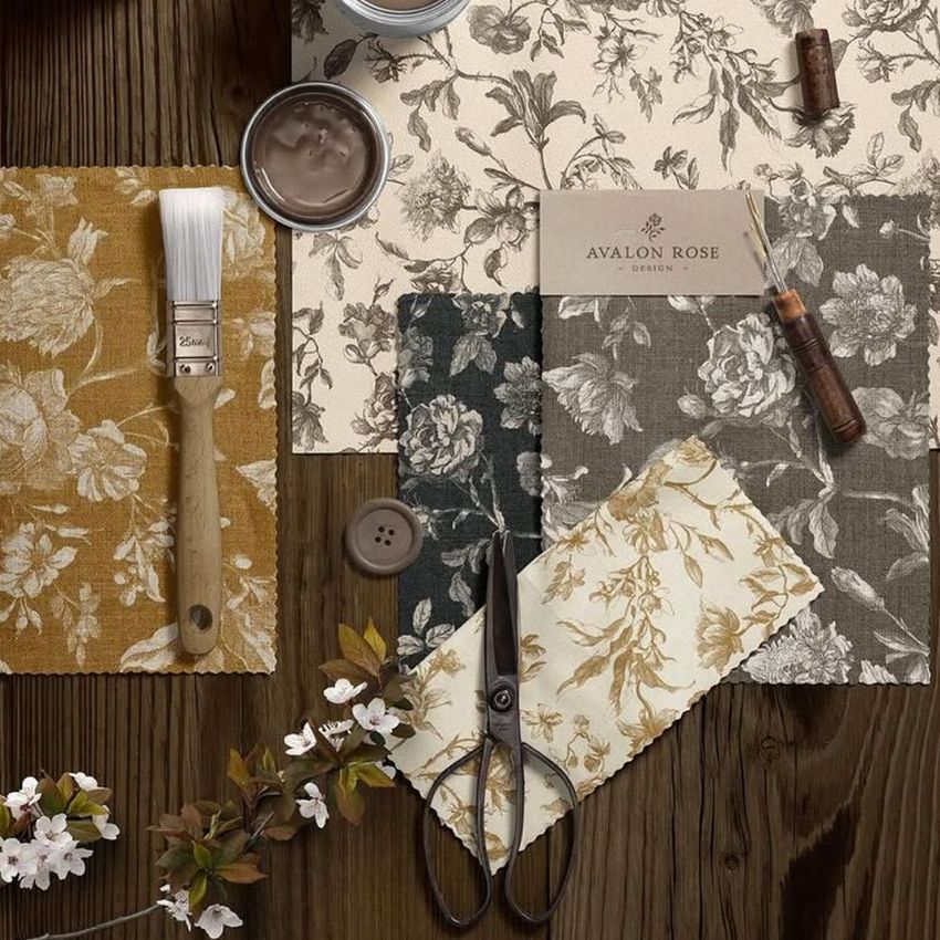 Rustic flat lay moodboard mockup featuring floral fabric swatches, scissors, paintbrush, button, and a business card on wooden surface.