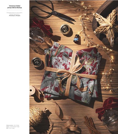 Christmas fabric mockup featuring folded textiles with holiday patterns, ribbon, and seasonal decorations on wood.