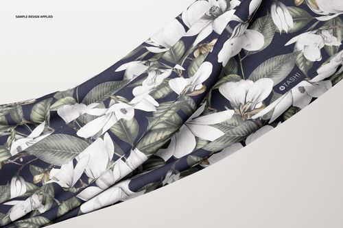 Close-up of a draped fabric mockup with a floral design in white and green tones against a navy backdrop.