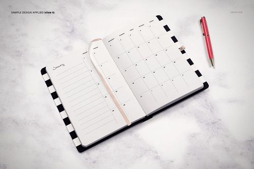 Top view of an open planner mockup with a striped edge, blank calendar pages, and a pink pen beside it.