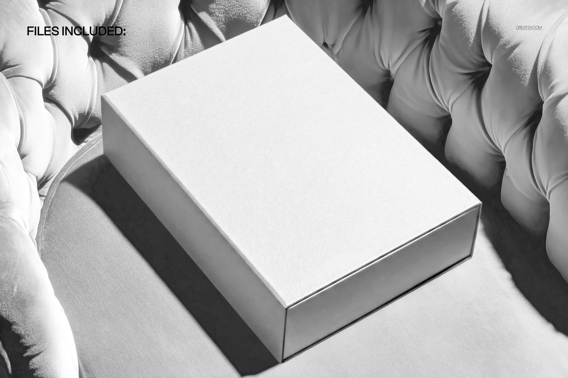 White premium packaging box mockup displayed on a plush velvet chair, showing a clean and elegant scene.