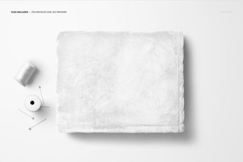 White fleece blanket mockup shown folded neatly with spool of thread and sewing pins on a light background.