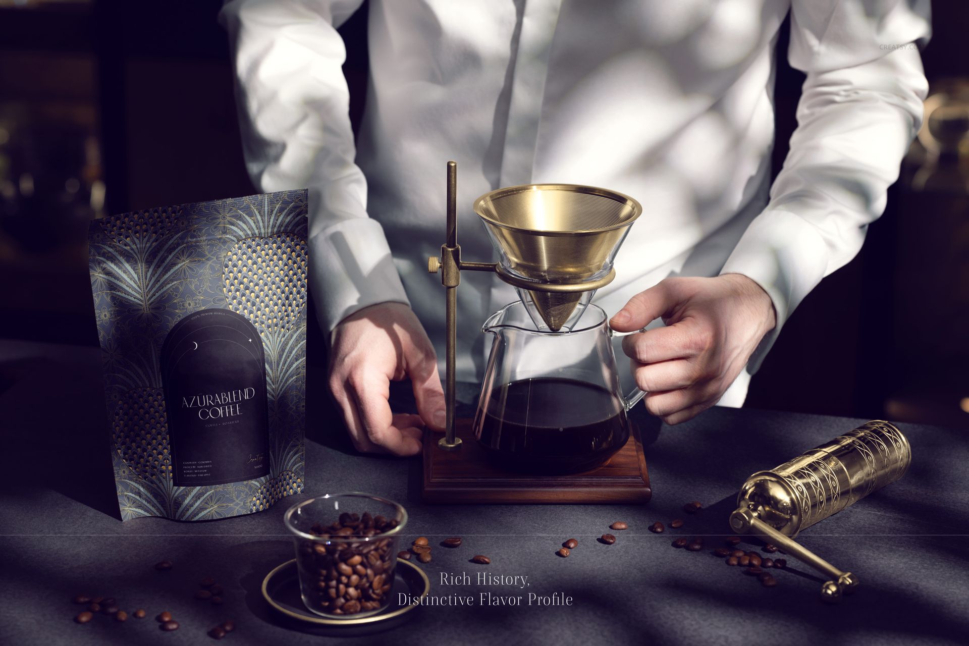 Front view of a coffee branding mockup set with packaging, glass carafe, brass pour-over stand, and coffee beans on a dark surface.