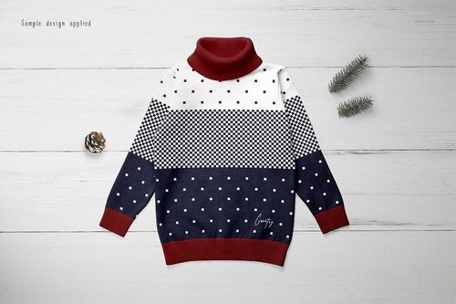 Kids turtleneck sweater mockup with red collar and cuffs, navy and white color blocks, and dotted patterns, top view.