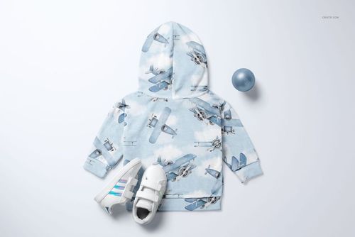 Light blue baby sweatshirt mockup with airplane illustrations, displayed with children’s sneakers and a blue plastic ball.