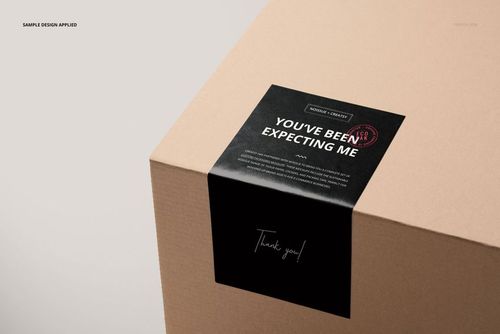 PSD mockup of a mailing box with a prominent black sticker, captured from an angled closeup view with minimal surroundings.