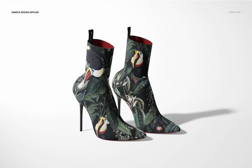 Mockup of ankle boots with high heels, decorated with vibrant jungle motifs and birds, displayed side by side in studio lighting.