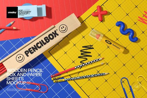 Stationery mockup featuring a wooden pencil box, vibrant pencils, and grid paper sheets arranged on a desk.
