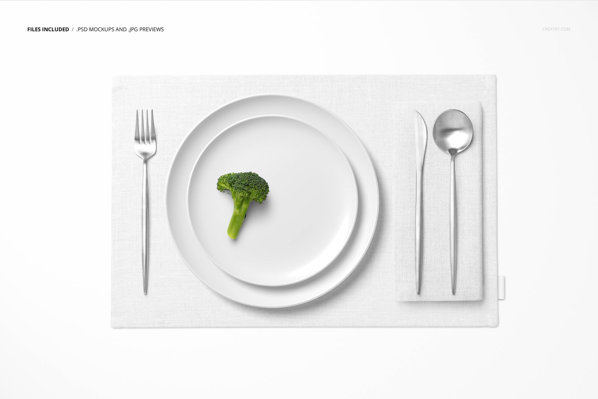 PSD mockup showing a minimal table setting with white placemat, cutlery, plate, and a single broccoli piece.