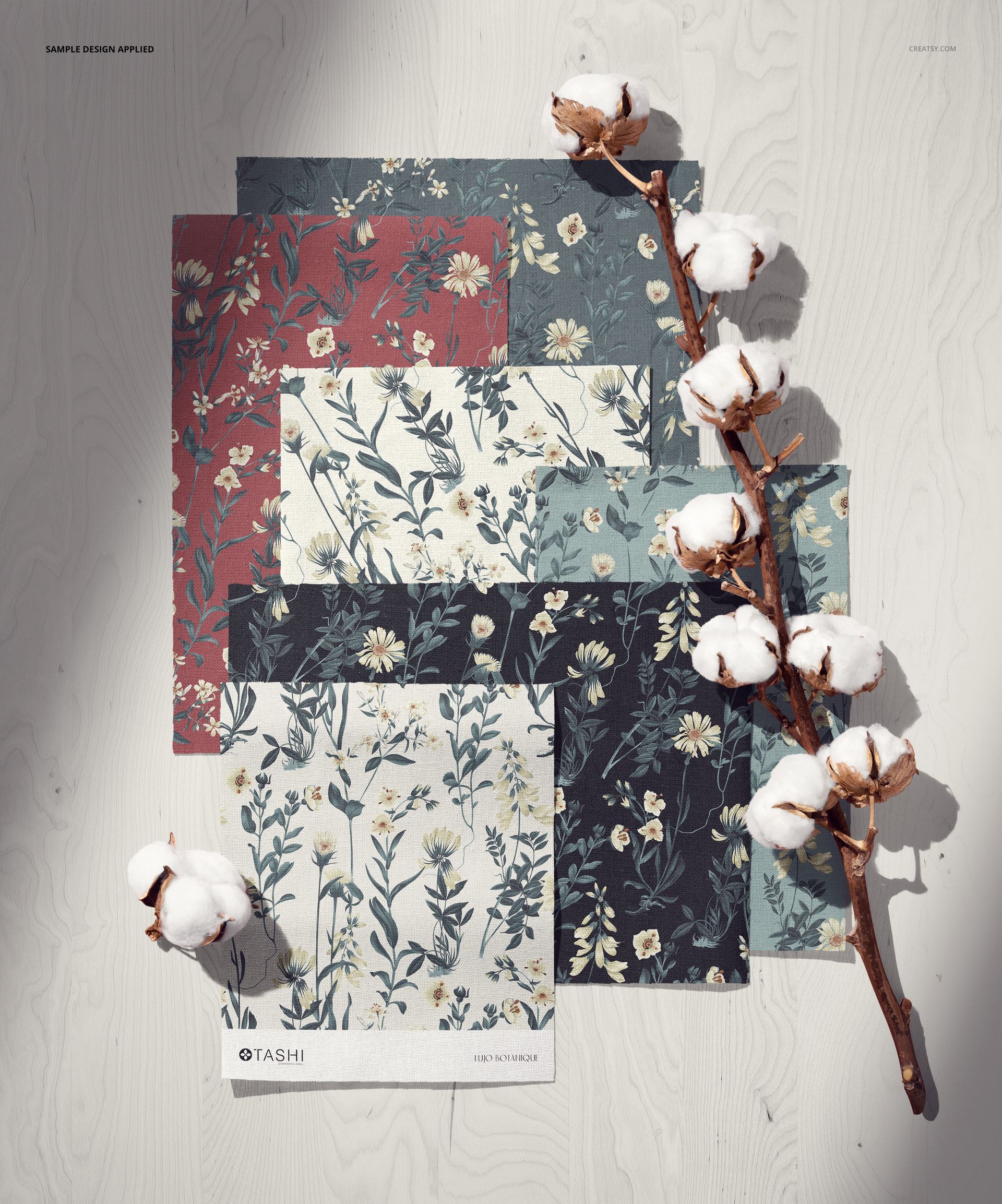 PSD mockup showing multiple cotton fabric samples in different floral prints, displayed on a pale wooden background with cotton stems.