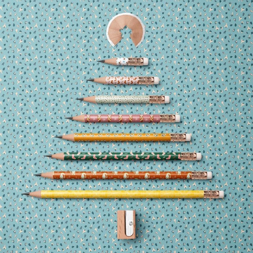 Pencil Christmas tree mockup showing sharpened pencils arranged in a tree shape on a blue patterned background with a sharpener.