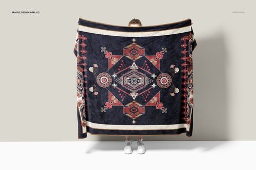 Front view of a fleece throw blanket mockup featuring intricate geometric motifs, held by a person in sneakers.
