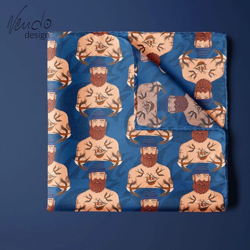 Pocket square mockup featuring a blue fabric with a repeating illustrated pattern of tattooed men with beards and mustaches.