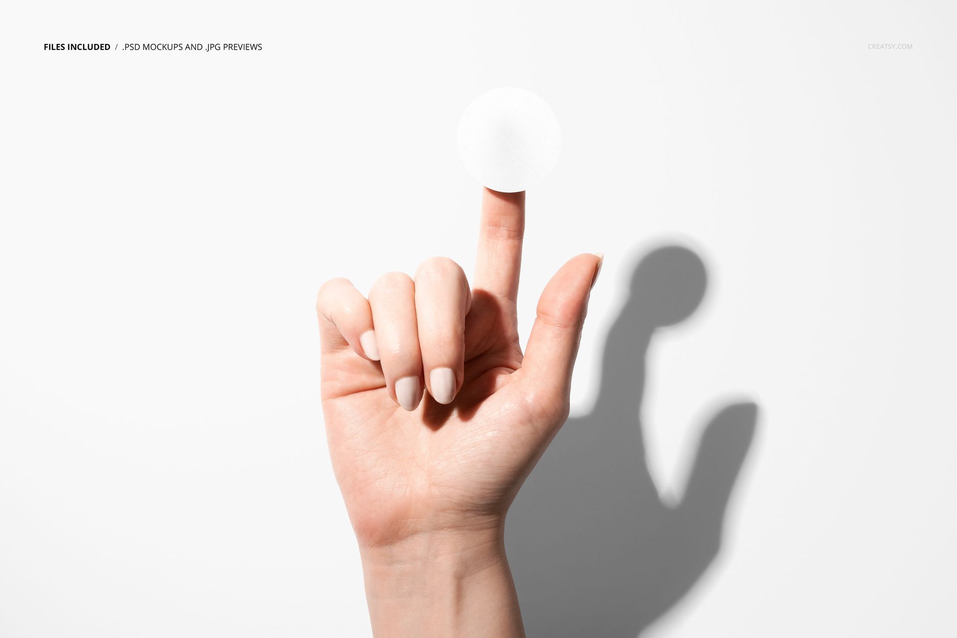 PSD mockup showing a single finger with a blank round sticker adhered to it, casting a shadow on a white surface.