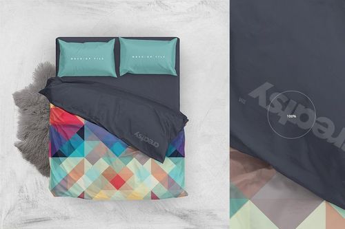 Double bed mockup with two aqua pillows and a geometric multicolor duvet, viewed from above on a light floor.
