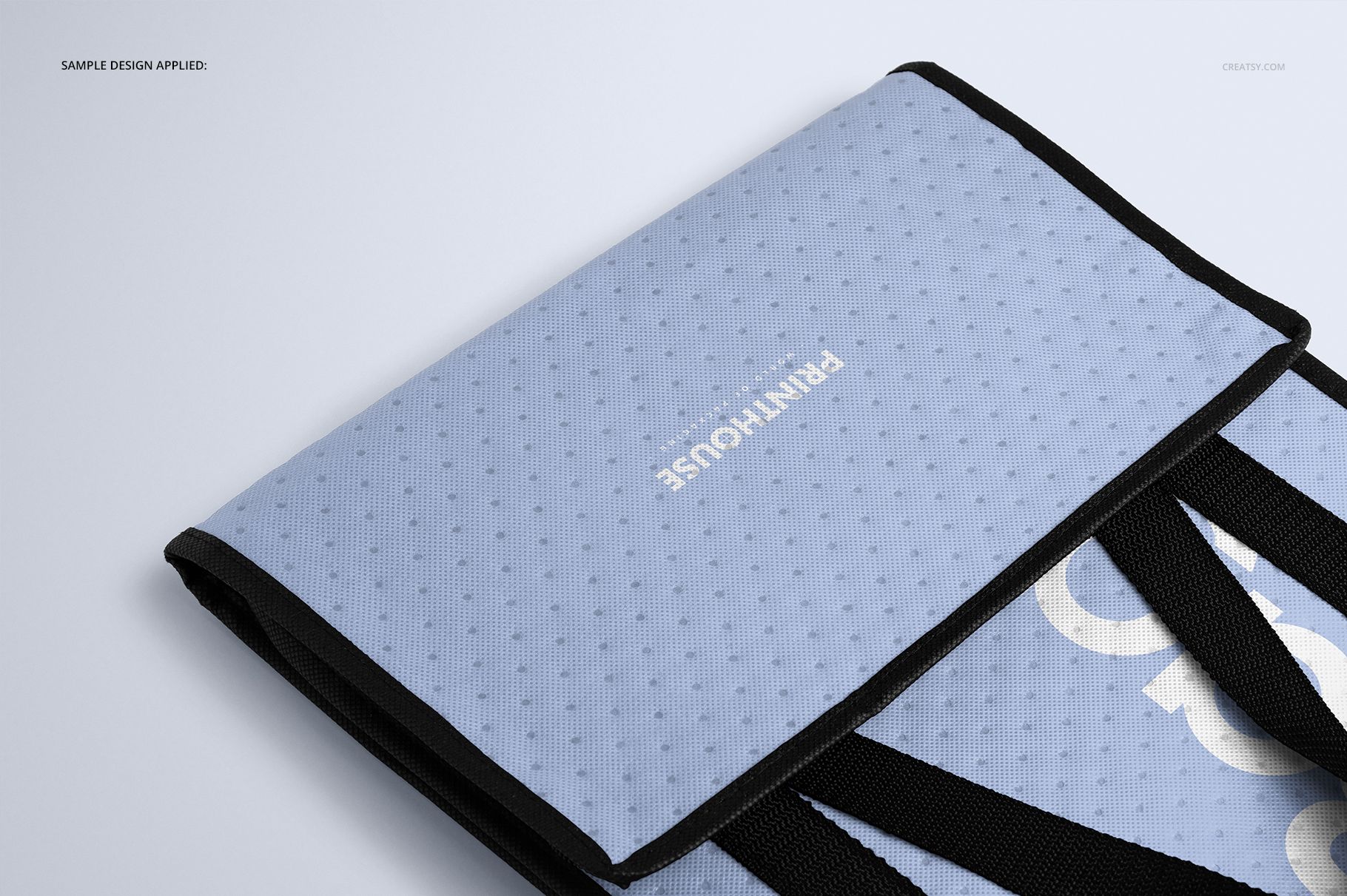 Front angled view of an insulated cooler bag mockup with a light blue textured surface and black handles on a plain background.