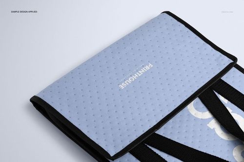 Front angled view of an insulated cooler bag mockup with a light blue textured surface and black handles on a plain background.