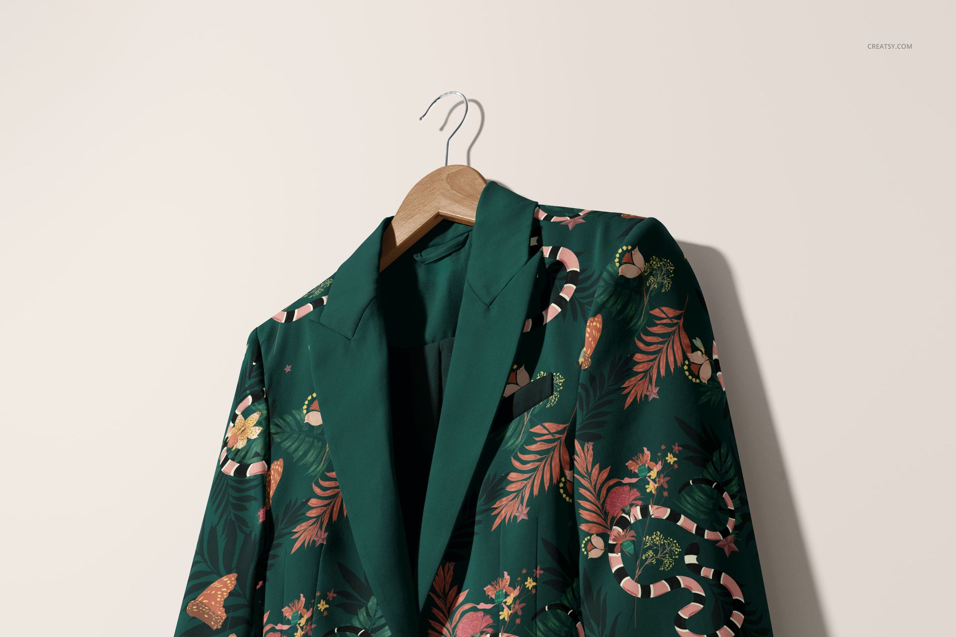 Elegant blazer mockup featuring a green jacket with colorful botanical and candy cane motifs on a hanger, well-lit scene.
