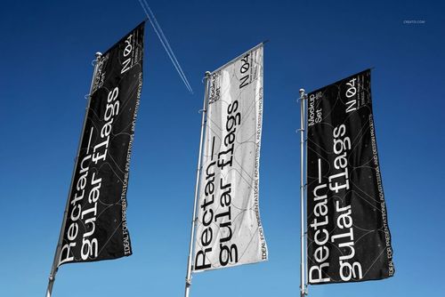 PSD mockup showing three rectangular advertising flags with text graphics, arranged on flagpoles under a bright sky.