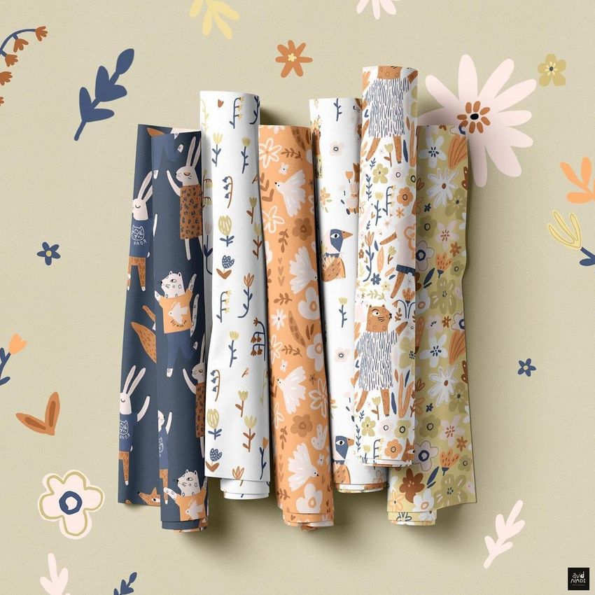 Fabric rolls mockup featuring six rolled fabrics with whimsical floral and animal patterns in muted pastel tones on a light background.