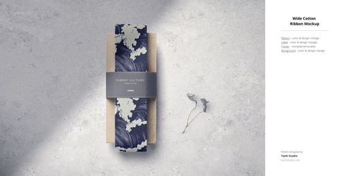 Wide cotton fabric ribbon mockup displayed on a light stone surface with a dried leaf and minimal packaging.