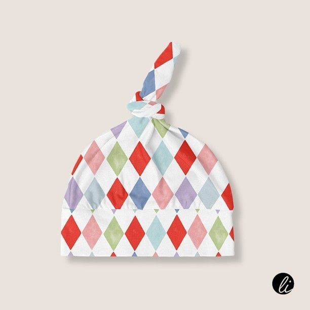 Swaddle set mockup featuring a baby hat with a top knot, decorated in a colorful diamond pattern on a light beige background.