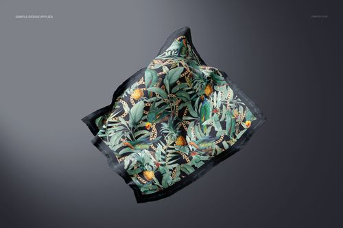 Floating square silk scarf mockup featuring a botanical and animal print, shown from a top view on a dark background.