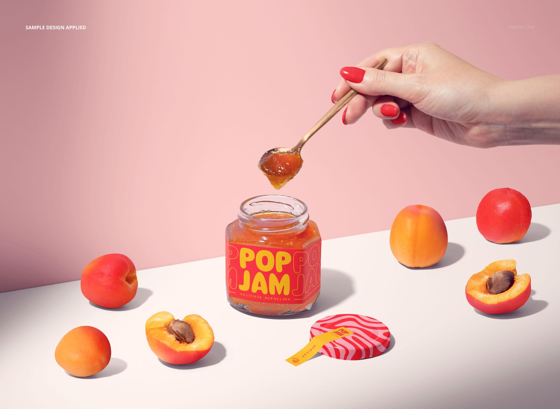 PSD mockup featuring an apricot jam jar with orange label, spoon held above, and apricots arranged nearby.