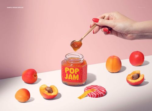 PSD mockup featuring an apricot jam jar with orange label, spoon held above, and apricots arranged nearby.