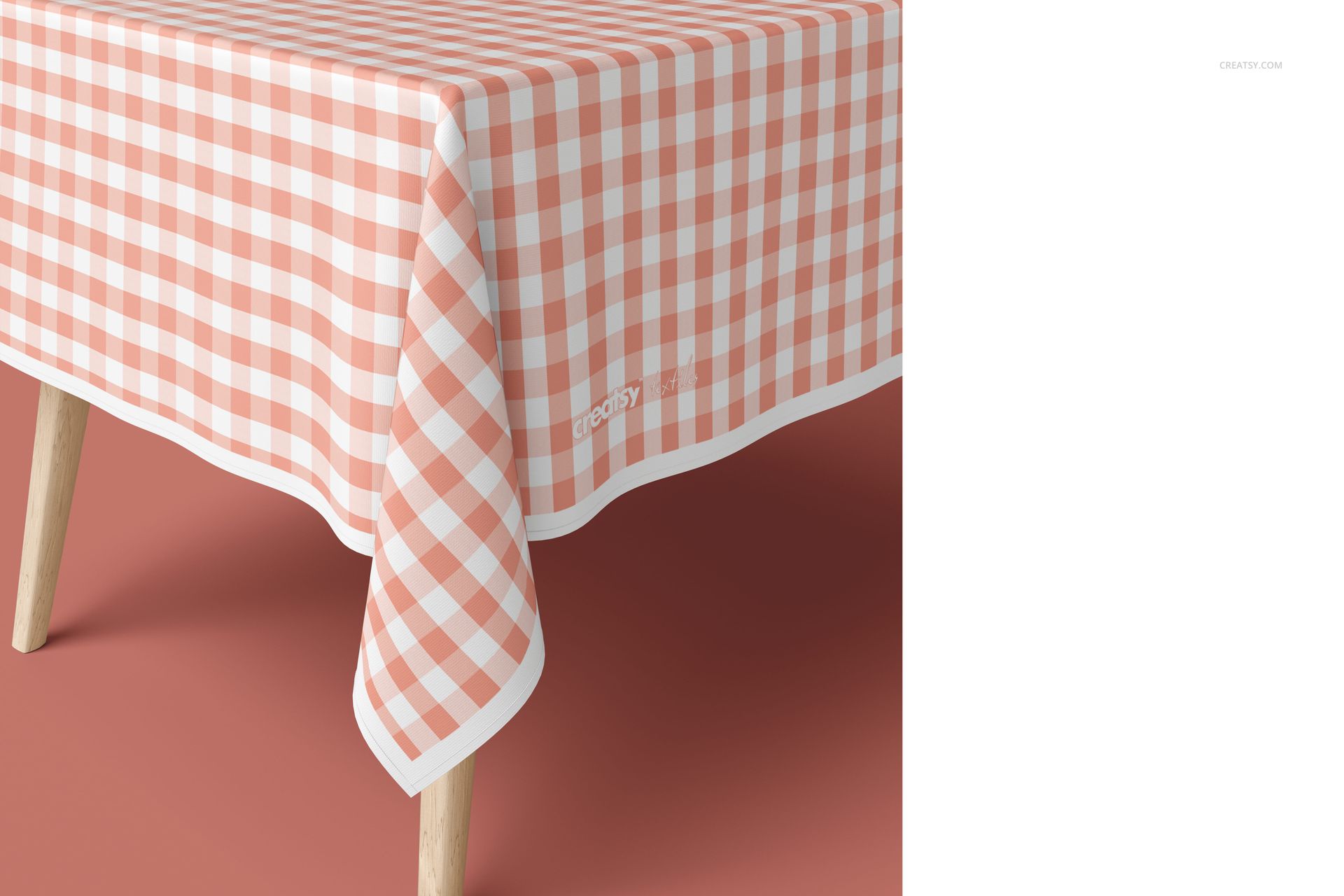 Tablecloth mockup featuring a pink and white gingham design on a table, shown from a close-up angled perspective.