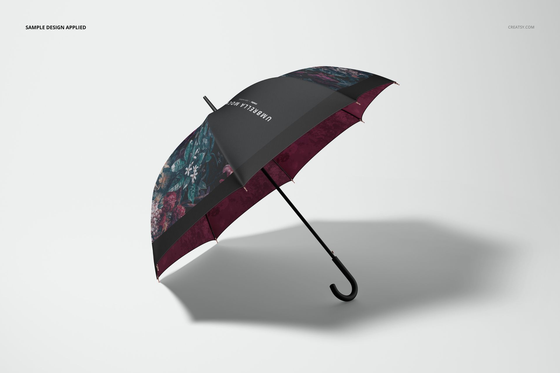 Umbrella mockup featuring a mix of burgundy and black sections with floral designs, angled on a neutral background.