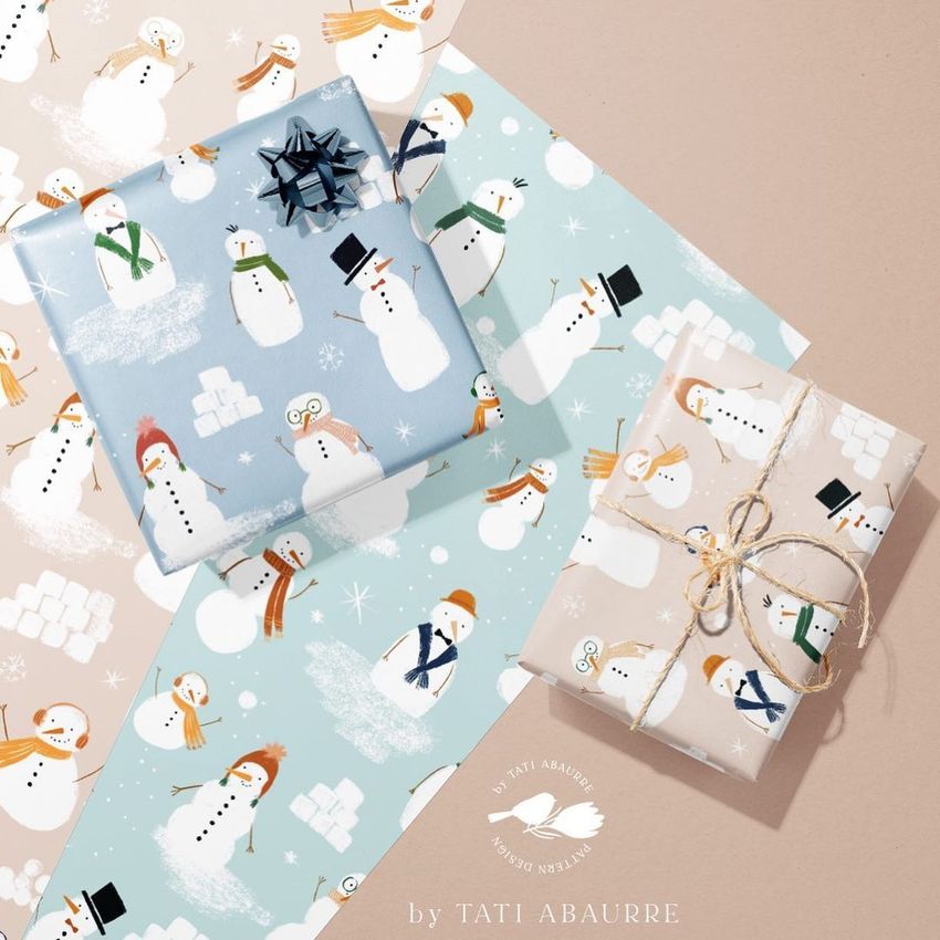 Gift wrapping paper mockup featuring two wrapped boxes with snowman patterns, displayed on pastel sheets with winter designs.