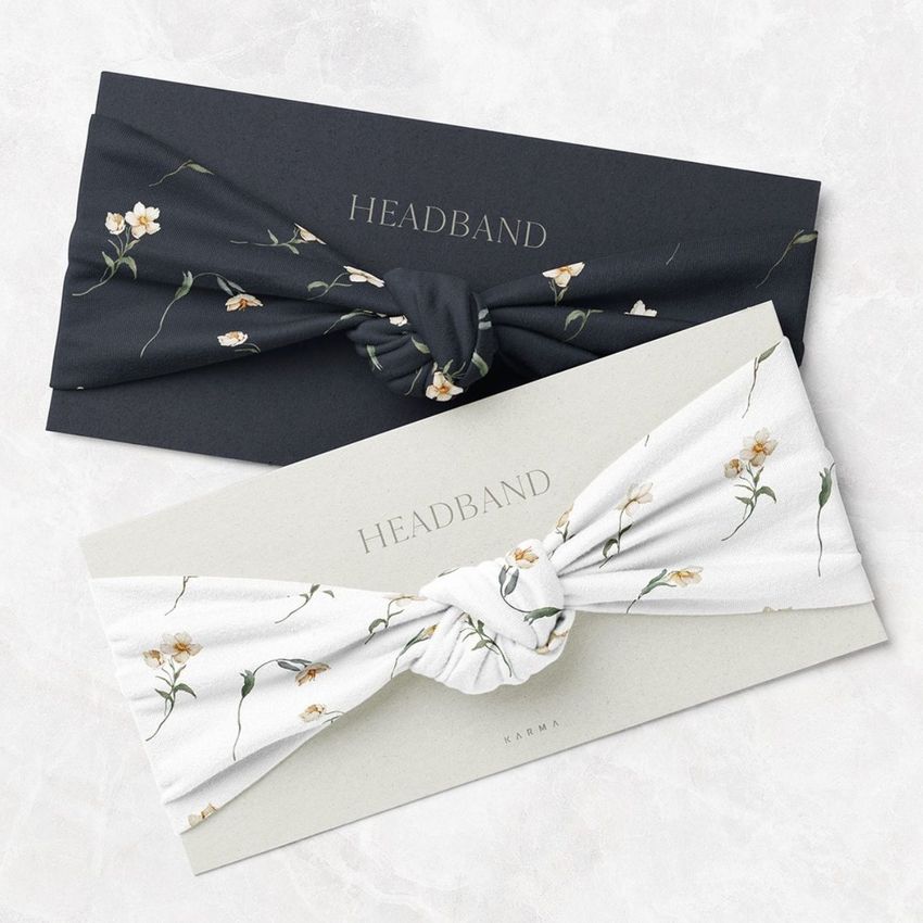 Kids headband mockup featuring two twist knot style headbands, one black and one white, both with delicate wildflower patterns.